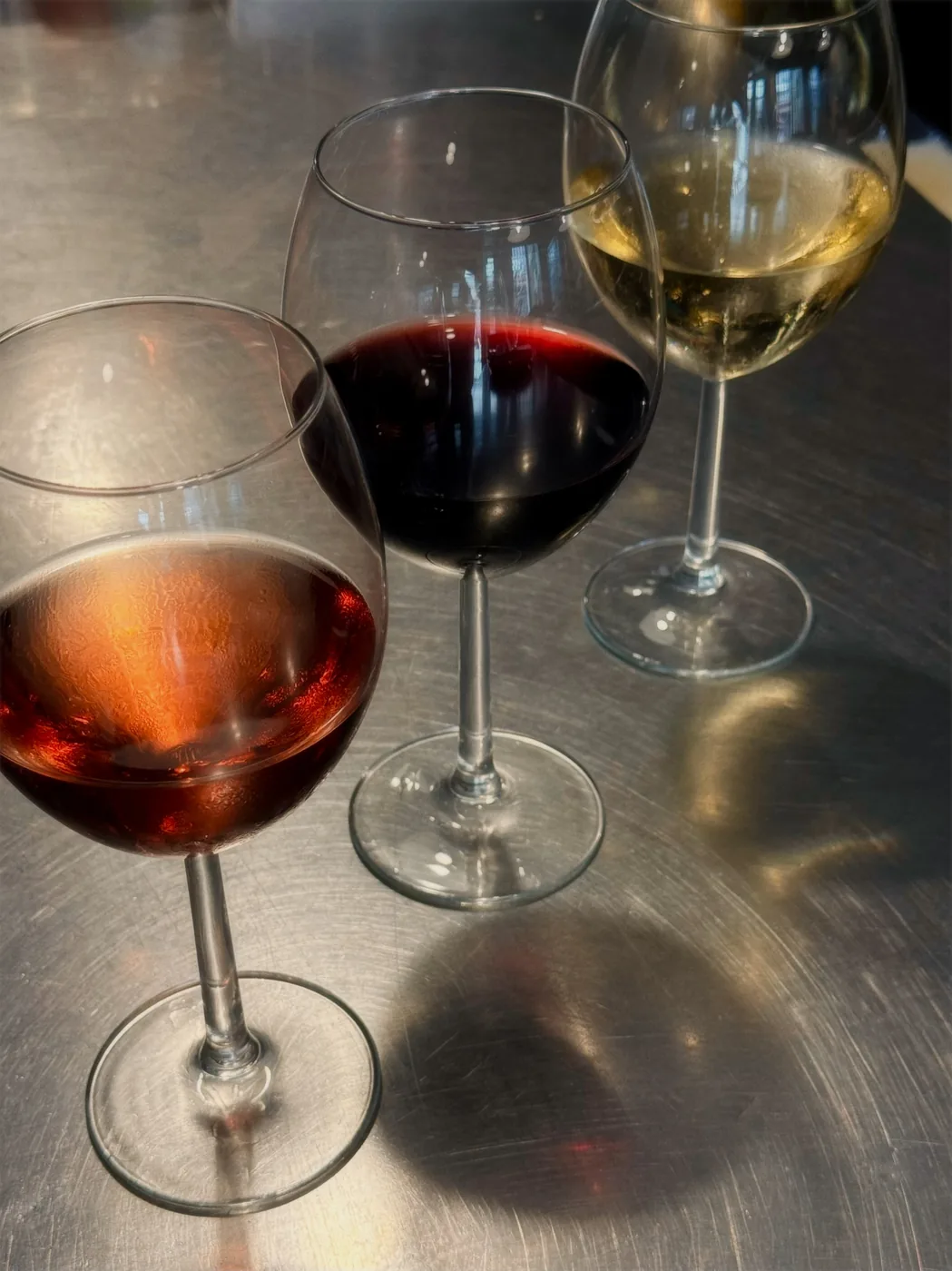 Tres copas de vino sobre la barra al atardecer